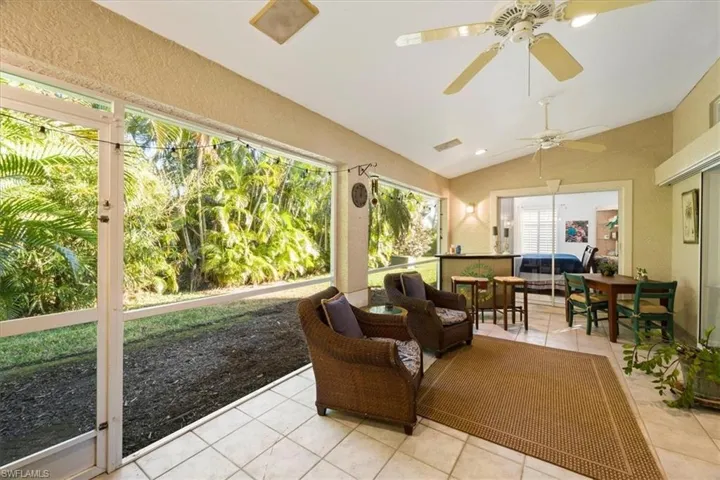 Sunroom with ceiling fan, a wealth of natural light, and lofted ceiling