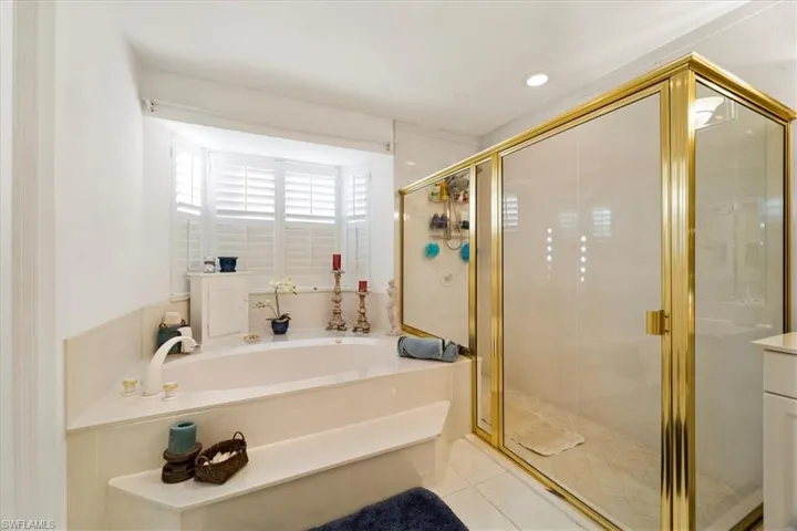 Bathroom featuring tile flooring, vanity, and plus walk in shower
