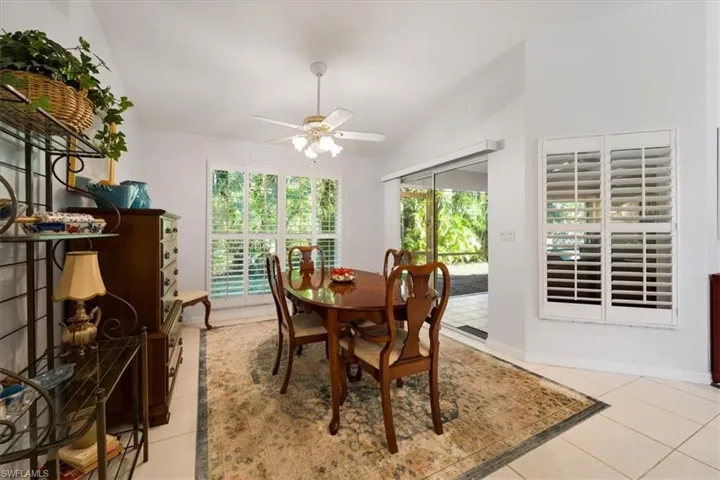 Dining area featuring ceiling fan, light tile floors, and lofted ceiling