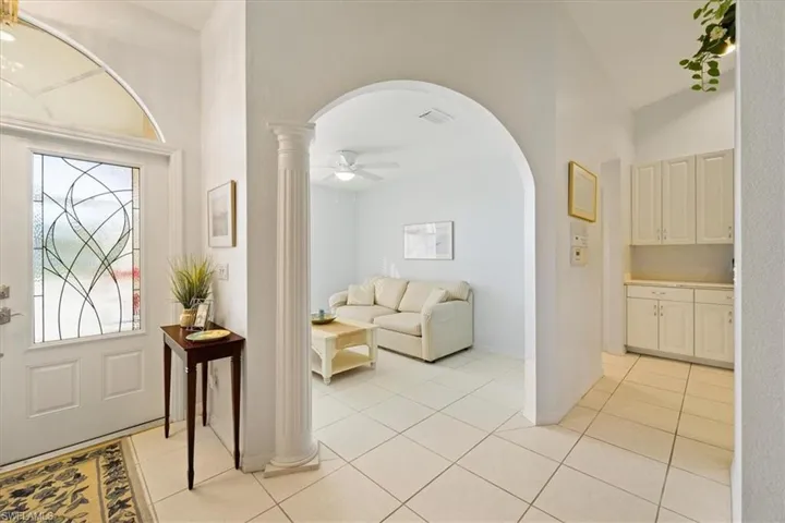 Tiled entrance foyer featuring high vaulted ceiling, ceiling fan, and a wealth of natural light