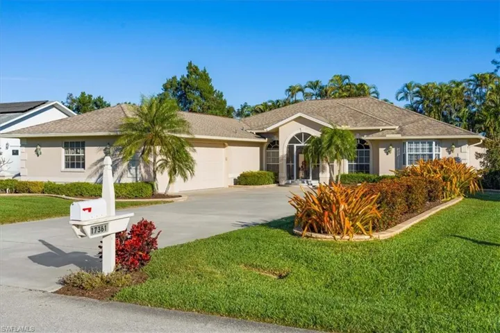 Single story home featuring a garage and a front lawn