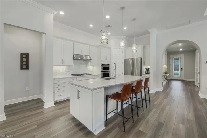 Kitchen open to great room, dining area, and outdoor space.