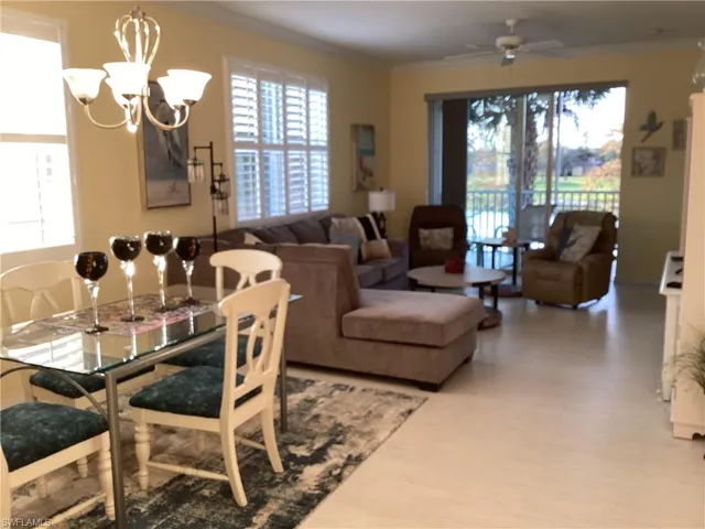 Dining space featuring a chandelier, crown molding, light wood-type flooring, and ceiling fan