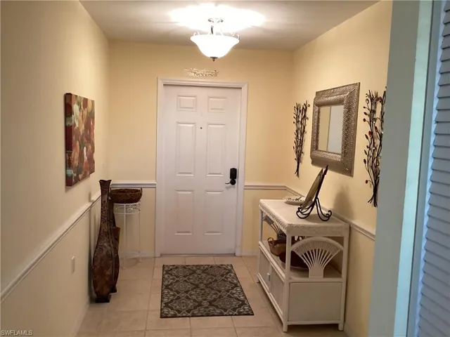 Foyer with light tile patterned flooring