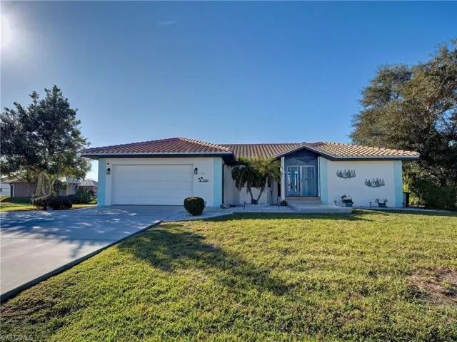 Mediterranean / spanish-style home with concrete driveway, a tile roof, a front yard, and stucco siding