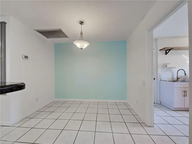 Unfurnished dining area with light tile patterned flooring and baseboards