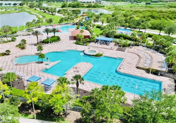 Community pool featuring a hot tub, a water view, and a patio area