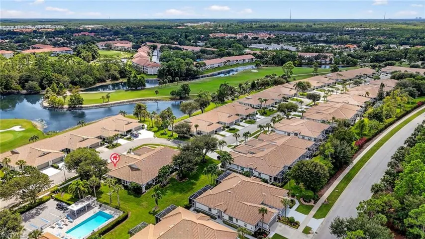 Aerial view of residential area with a local golf course and a nearby body of water