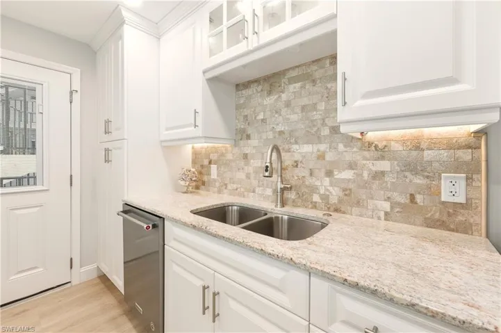 Kitchen featuring white cabinets, glass insert cabinets, and dishwasher