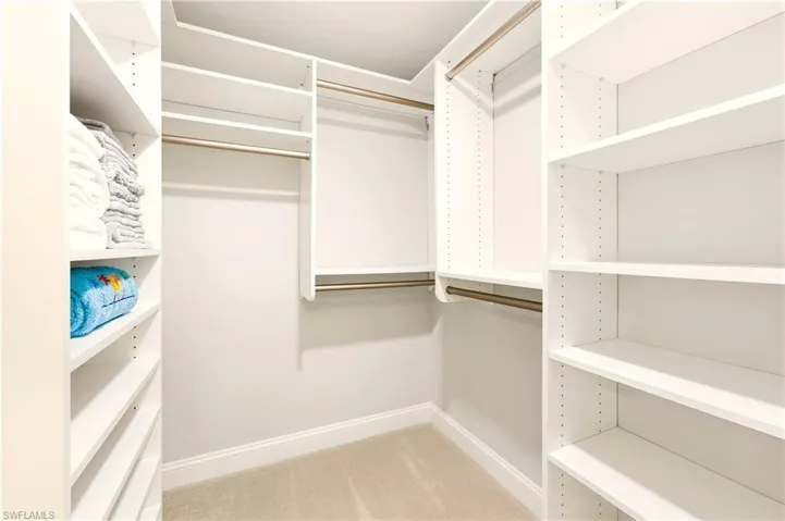 Spacious closet with light colored carpet
