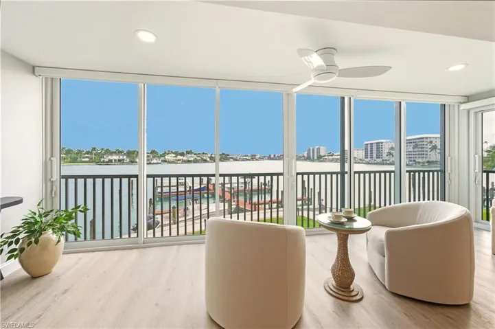 Sunroom with vinyl finished floors, expansive windows, recessed lighting, and a water view