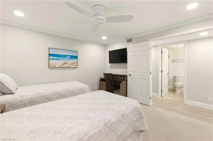 Bedroom with light carpet,crown molding, a ceiling fan, recessed lighting, hall bath