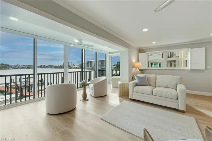 Living room with crown molding, vinyl floors, recessed lighting, and a water view