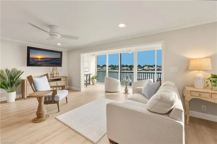 Living room featuring light vinyl flooring, crown molding, recessed lighting, and a ceiling fan