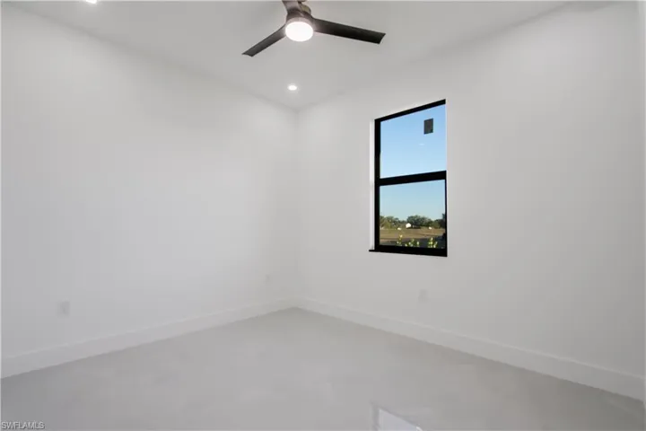 Empty room featuring recessed lighting, a ceiling fan, concrete floors, and baseboards