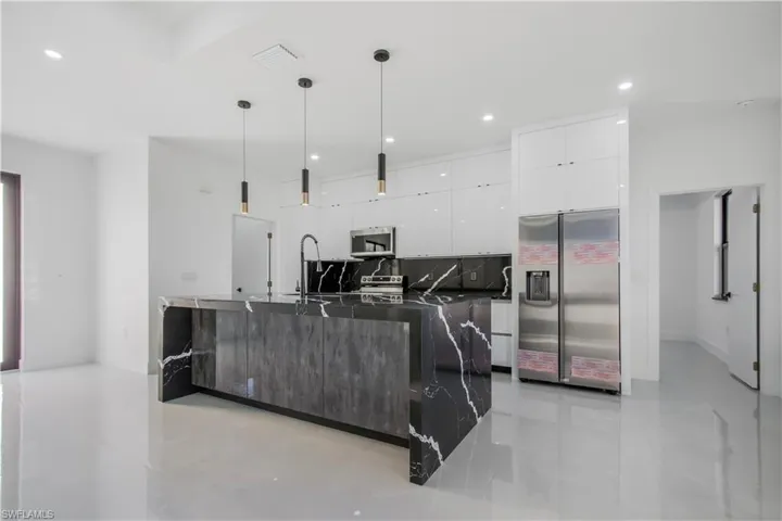 Kitchen featuring recessed lighting, appliances with stainless steel finishes, white cabinetry, dark countertops, and modern cabinets