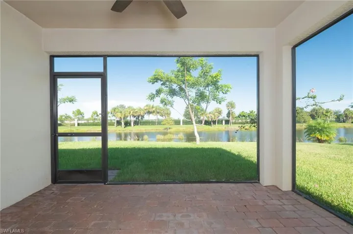 Unfurnished sunroom featuring a water view and brick flooring