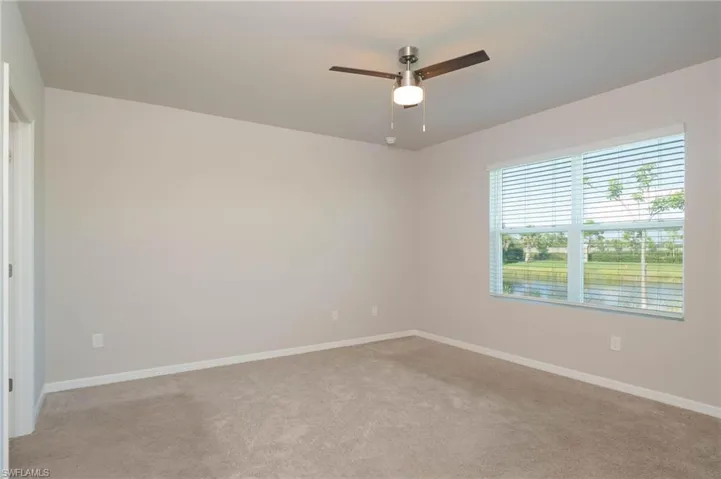 Unfurnished room featuring light carpet and ceiling fan