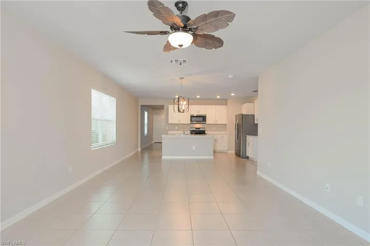 Unfurnished living room with light tile patterned floors, ceiling fan, and recessed lighting