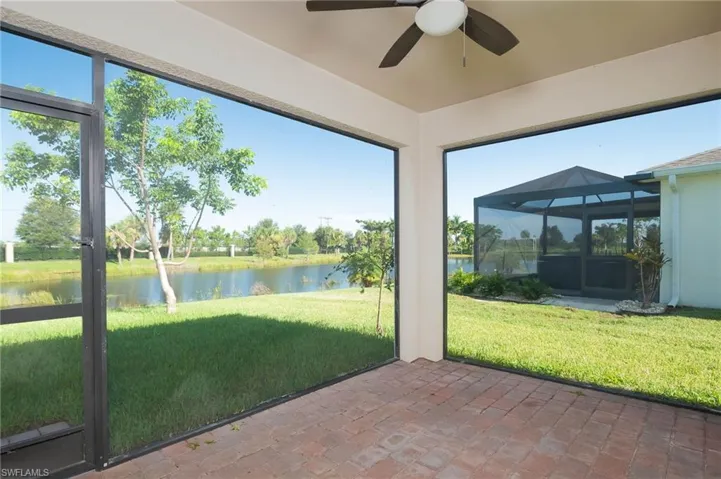 Unfurnished sunroom featuring a water view and a ceiling fan