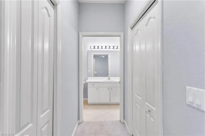 Corridor with sink and light colored carpet