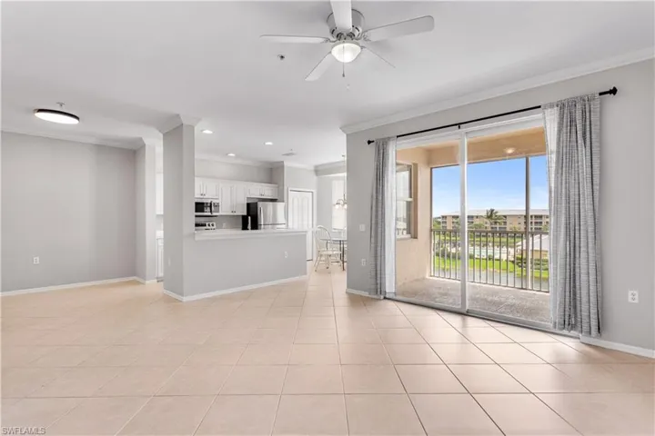 Unfurnished living room featuring ornamental molding and light tile flooring