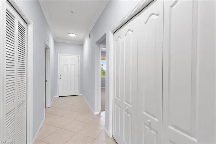 Hall featuring ornamental molding and light tile flooring