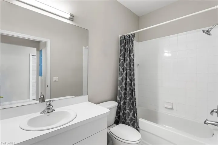 Full Guest bathroom with shower / tub combo with curtain, vanity, and toilet