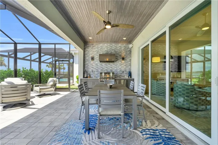 View of patio featuring a grill, ceiling fan, and a lanai