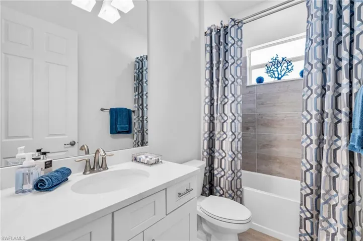 Full bathroom with vanity, toilet, and shower / bathtub combination with curtain