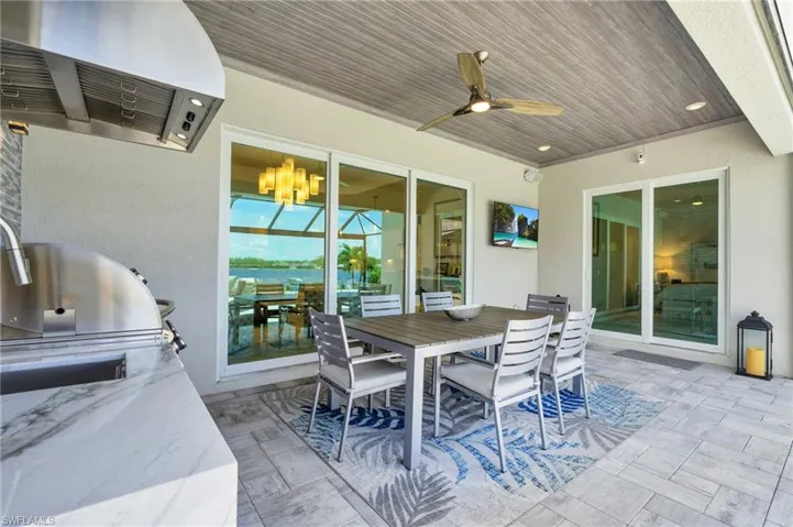 View of patio with exterior kitchen, area for grilling, and ceiling fan