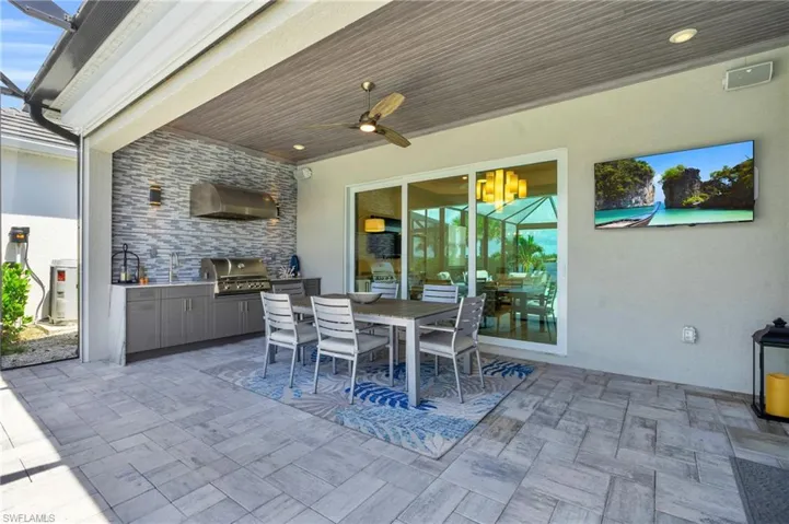 View of patio with exterior kitchen, area for grilling, sink, and ceiling fan