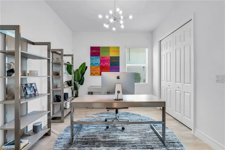 Office space with light tile patterned floors and a notable chandelier