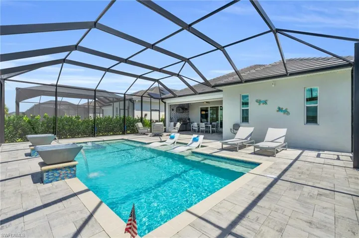 View of swimming pool featuring a lanai, pool water feature, and a patio area