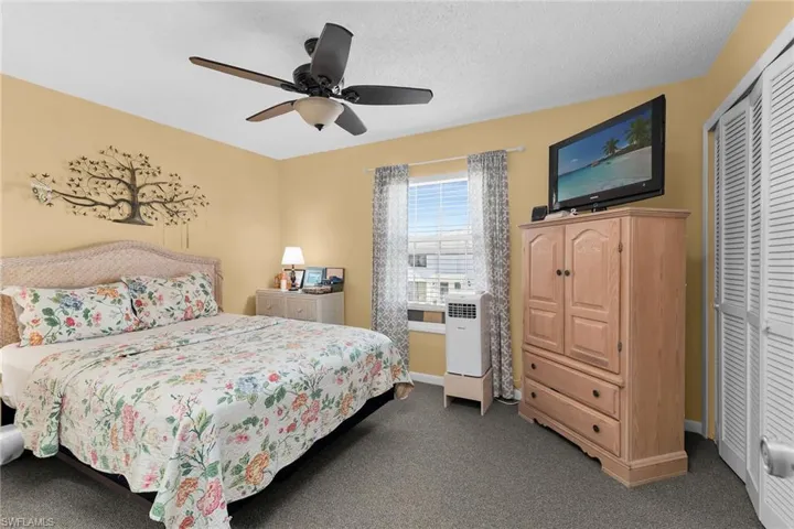 Bedroom featuring ceiling fan, a closet, carpet flooring, and a textured ceiling