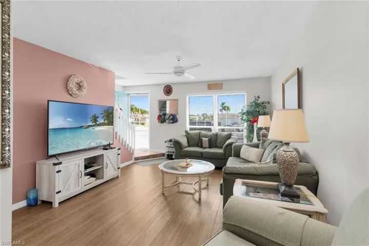 Living room featuring wood finished floors, ceiling fan, and a textured ceiling