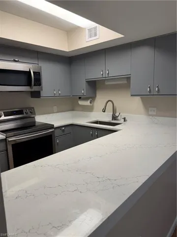 Kitchen with stove and gray cabinets