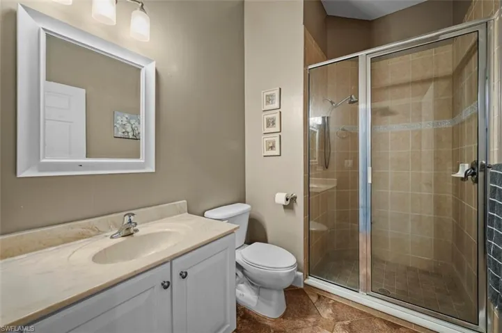 Bathroom with vanity, toilet, and a shower with shower door