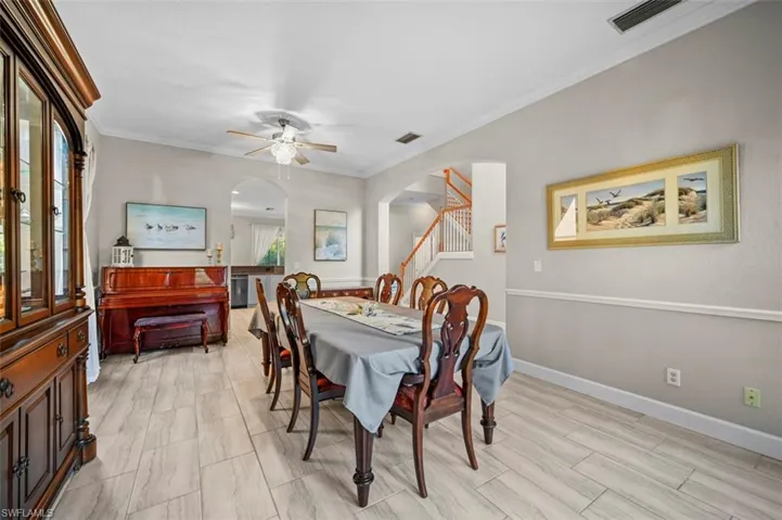 Dining room with ceiling fan, light wood-type flooring, and crown molding