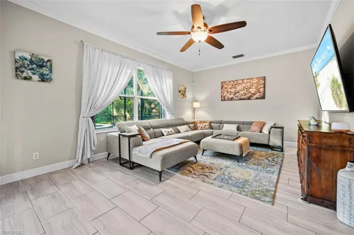 Living room with ceiling fan and ornamental molding
