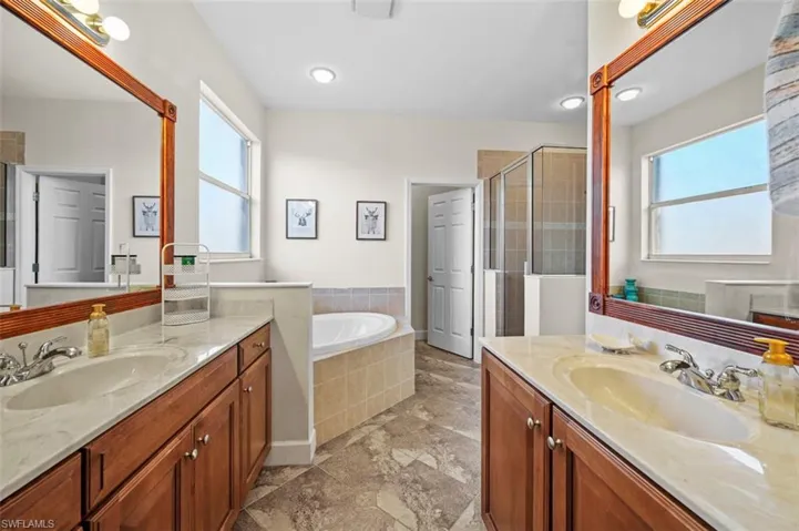 Bathroom featuring vanity and plus walk in shower