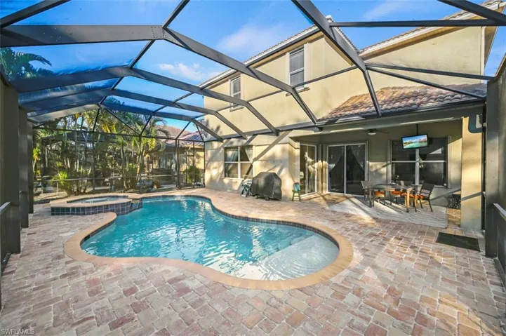 View of pool with a lanai, an in ground hot tub, and a patio