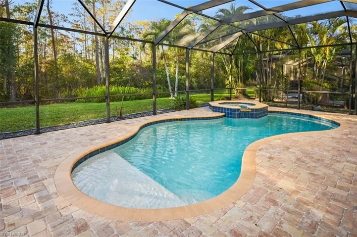 View of swimming pool with a lanai, a patio, and an in ground hot tub