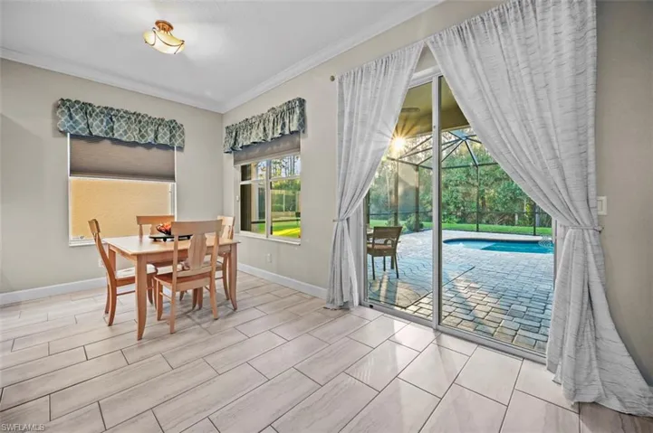 Dining space with ornamental molding and light hardwood / wood-style flooring