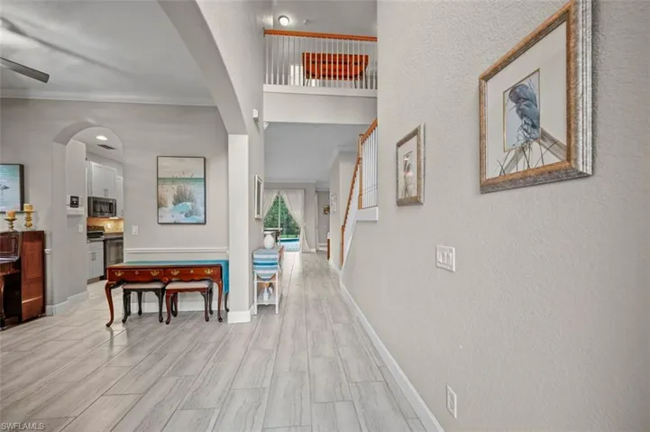Corridor with ornamental molding and light hardwood / wood-style flooring