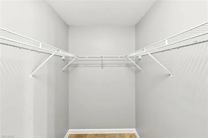 Walk-in closet featuring light gray painted walls and white wire shelving
