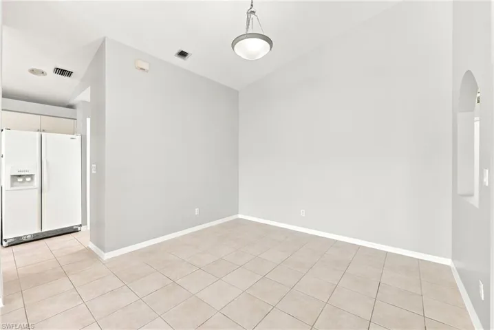 Open concept room with neutral wall tones and tile flooring