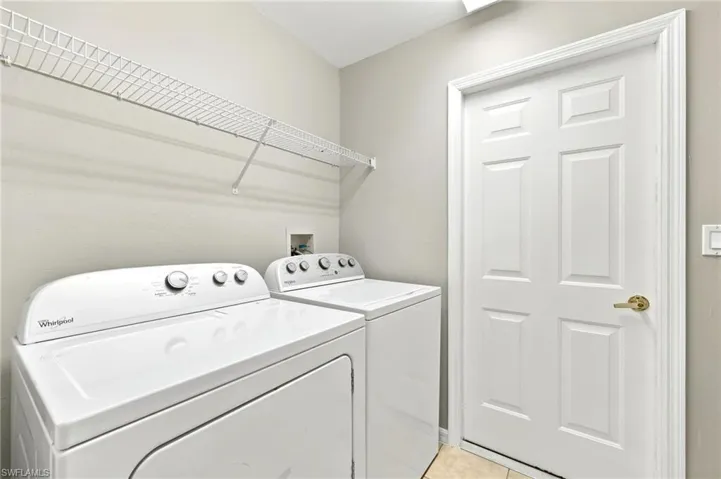 Dedicated laundry area featuring a white wire shelving unit and light beige wall paint