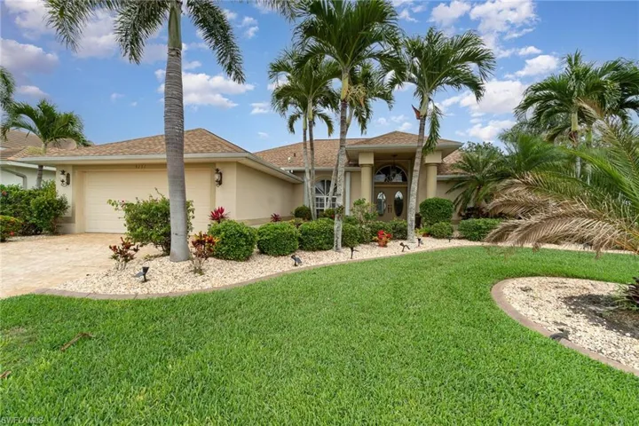 View of front of house featuring an attached garage, driveway, stucco siding, and a front lawn