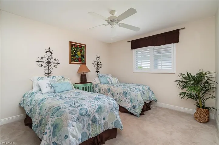 Carpeted bedroom featuring baseboards and a ceiling fan